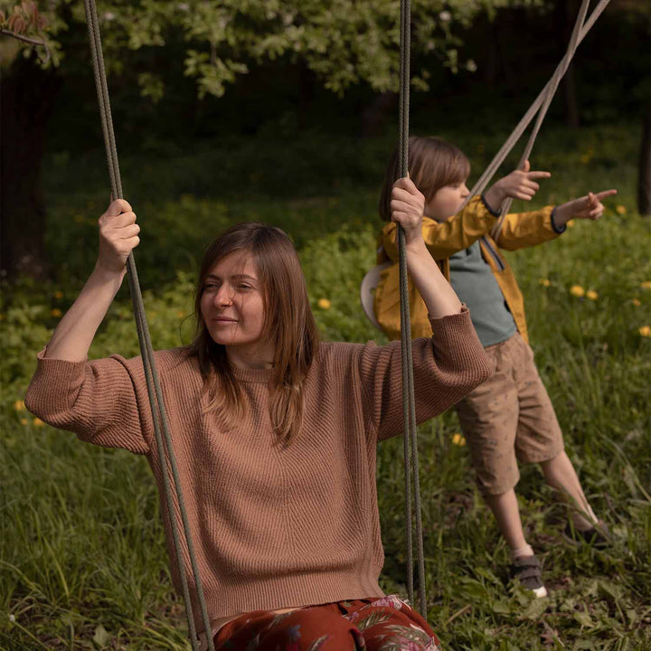 Maman et enfant sur des Balancoires en bois 