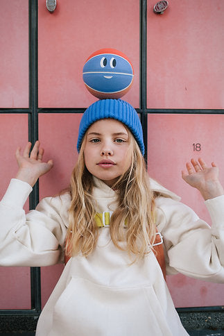 Enfant avec Ballon sportif bleu et orange sur la tête