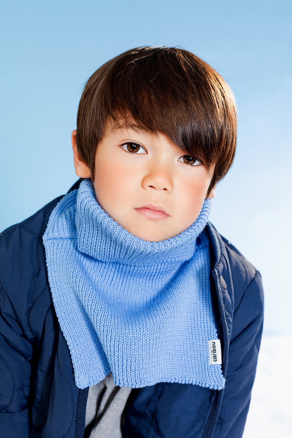 Enfant avec Cache-cou Caribou en tricot bleu