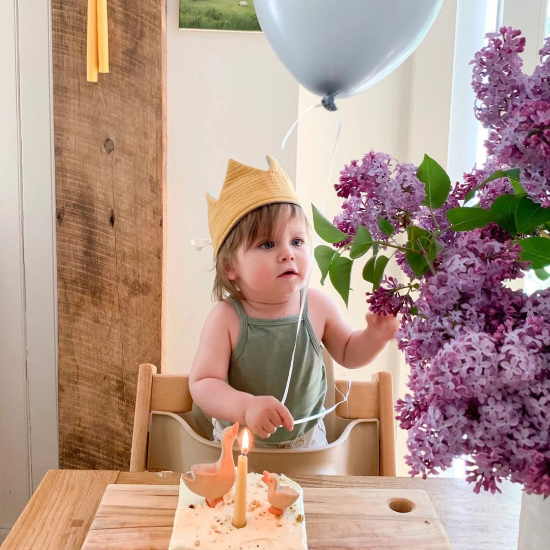 Enfant avec Couronne réversible en tissu jaune et écru avec pompons gris