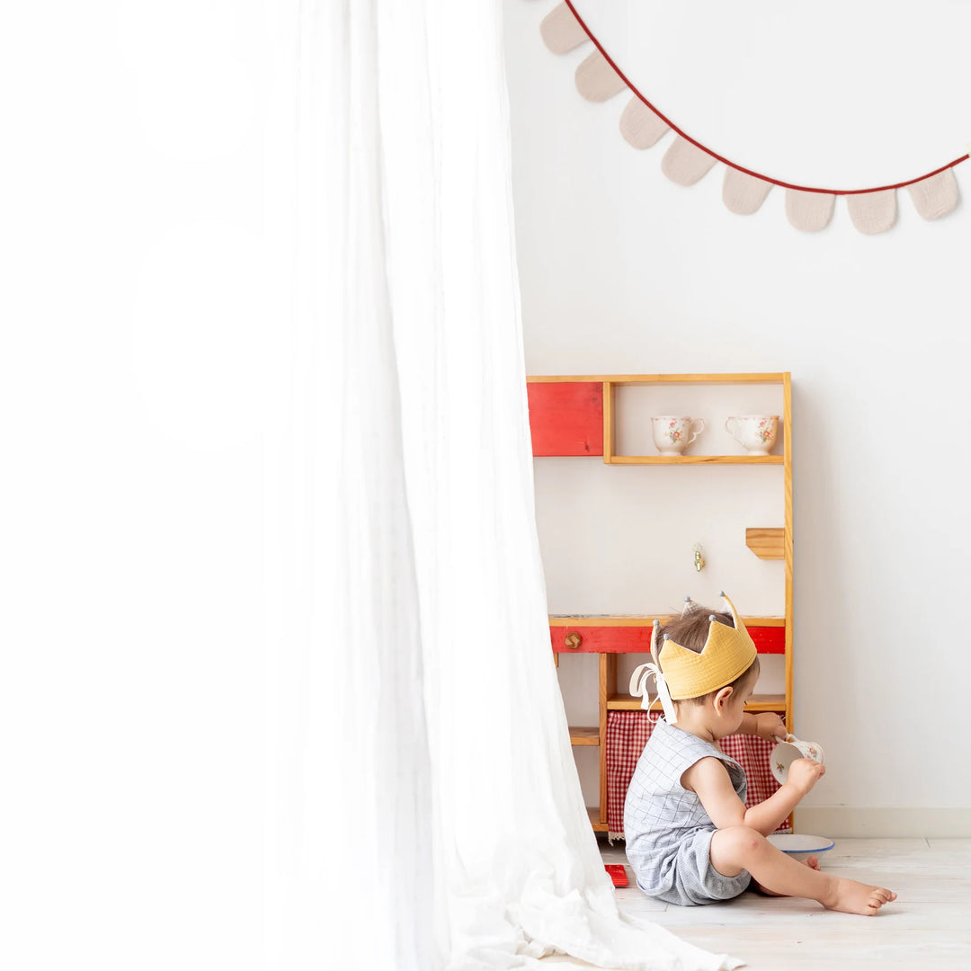 Enfant avec Couronne réversible en tissu jaune et écru avec pompons gris