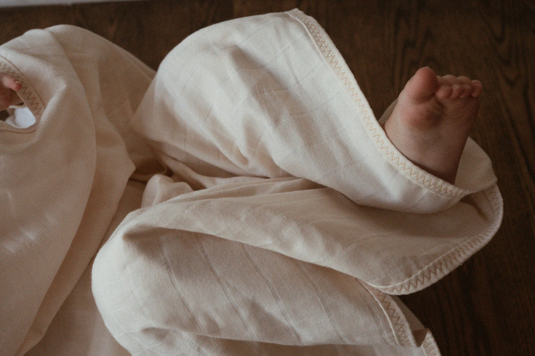 Pied de bébé avec Couverture carrée en coton biologique naturel