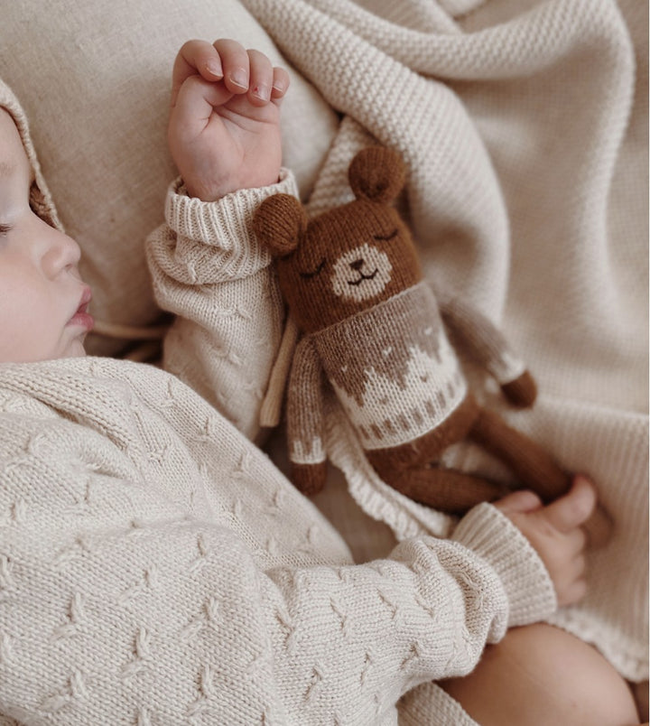Bébé avec Doudou ourson en tricot avec Pull jacquard avoine
