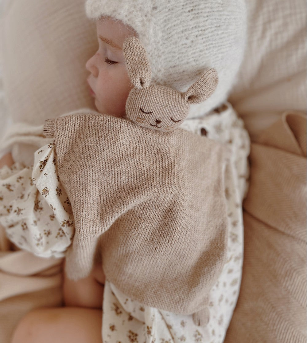 Bébé avec Doudou plat tricoté Lapin sable