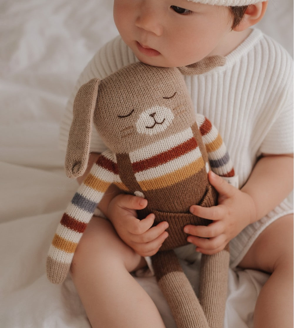 Bébé avec Grand Lapin en peluche Pull arc-en-ciel