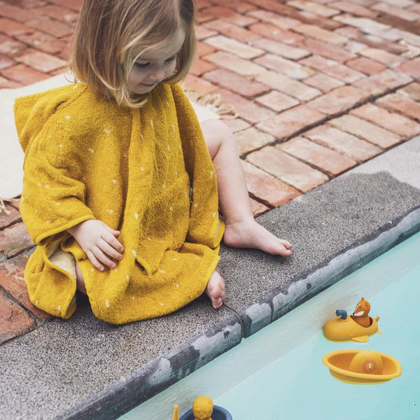 Fille avec Jouet de bain sous-marin jaune et renard en silicone dans une piscine