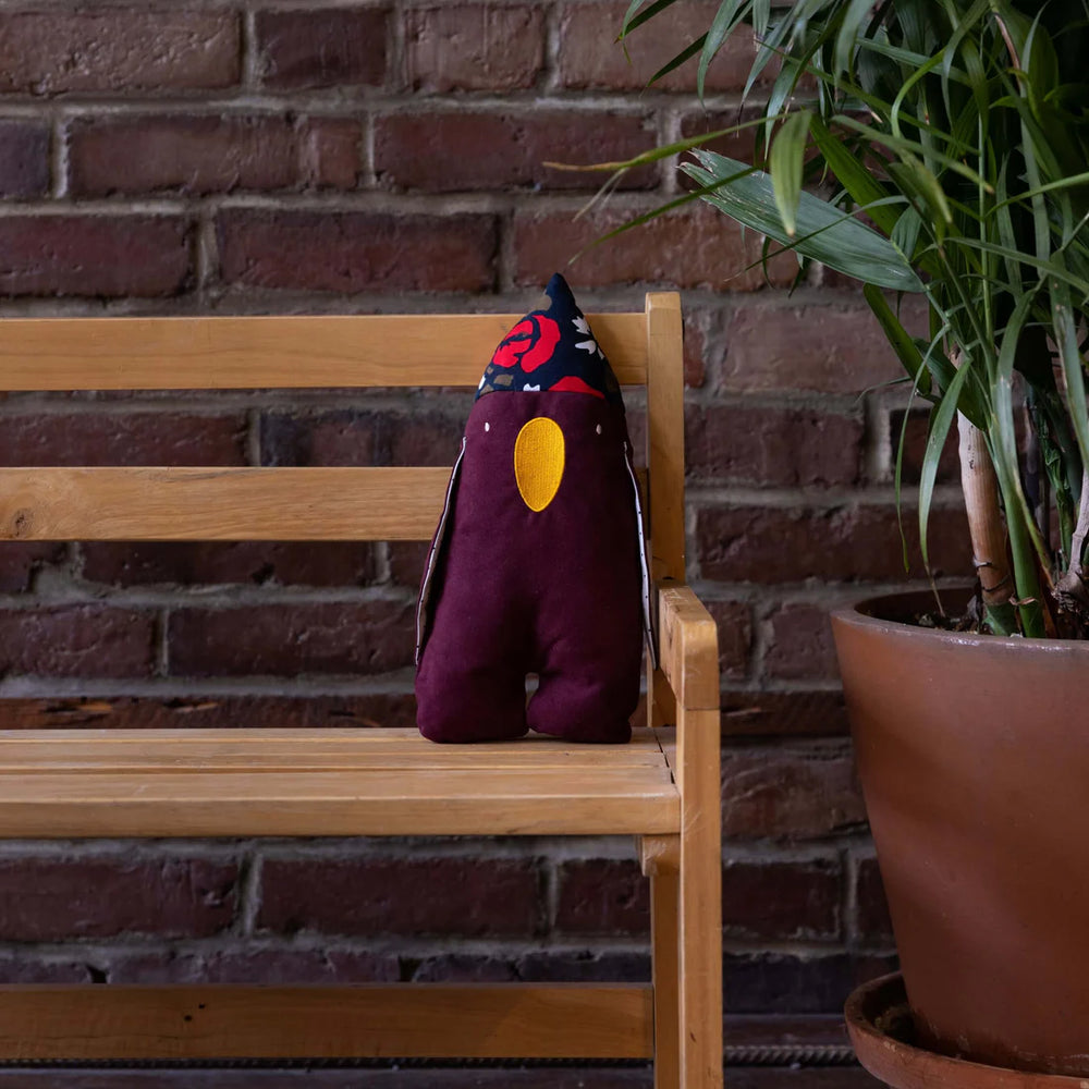 Peluche Raplapla Karim le pingouin mauve  sur un banc