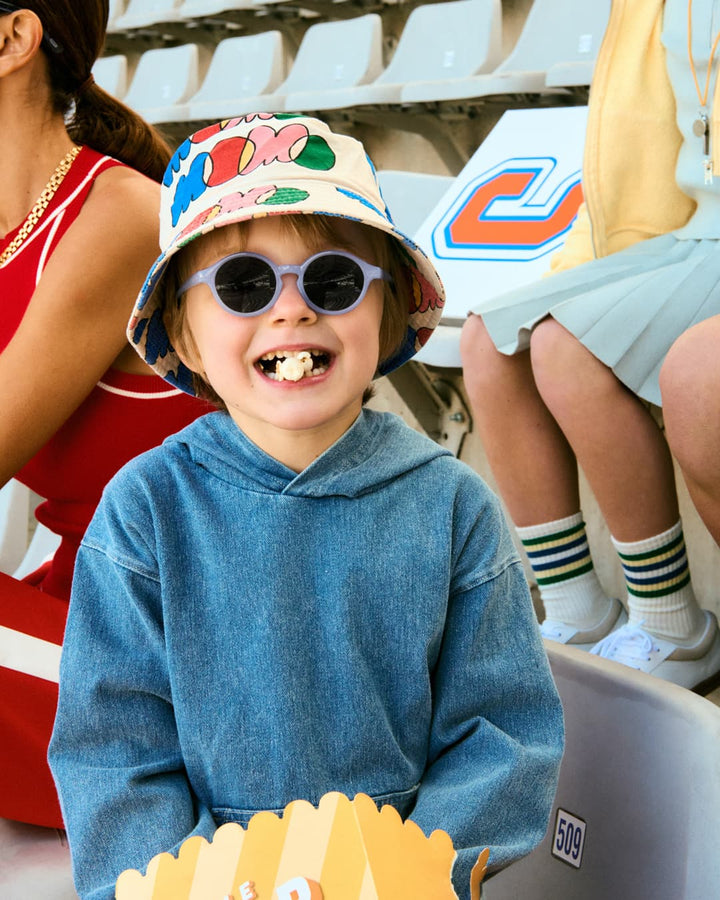 Enfant dans un stadium avec Lunettes de soleil pour enfants Izipizi violet transparent