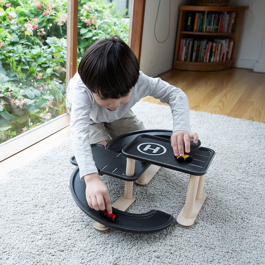 Enfant qui joue avec Mon premier garage en bois PLan Toys