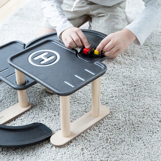 Mains d'enfant avec Mon premier garage en bois PLan Toys