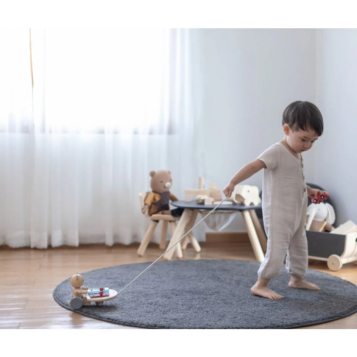 Enfant avec Ours musical en bois à tirer