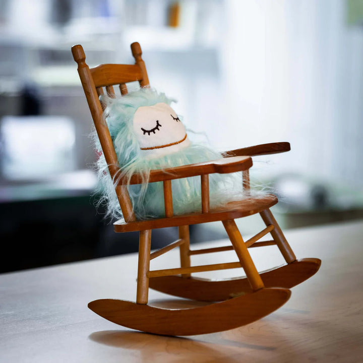 Peluche Raplapla Gri gri Aquamarine yeux fermés dans une chaise berçante