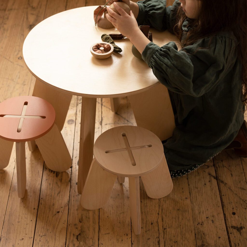 Fille qui joue sur un Table et tabourets 