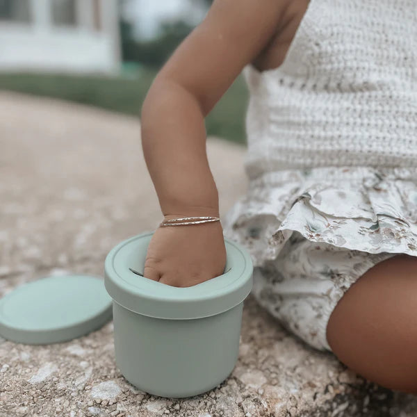 Bras d'enfant avec une Tasse à collation anti-déversement en silicone 