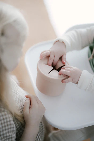 Mains de bébé avec Tasse à collation anti-déversement