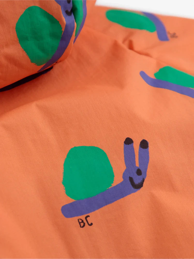 Détail de Veste réversible pour bébé en 100% Polyamide recyclé orange avec imprimé escargots 