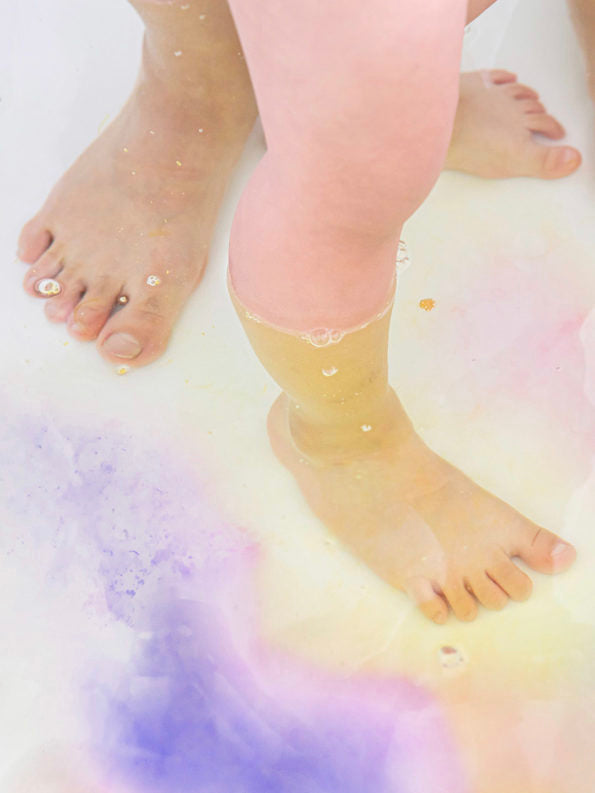 feet in a colorful bath tub with bubble bath